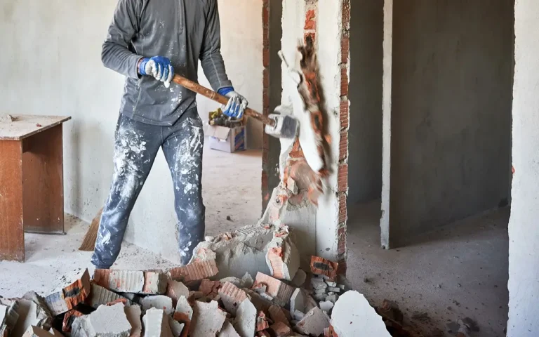 a man with a hammer hitting a wall with bricks