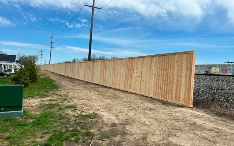 a long wooden fence on a dirt road