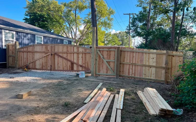 a fence and wood planks in a yard